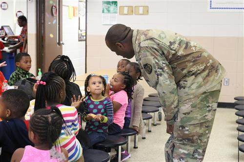 Soldier talking to students in cafeteria 